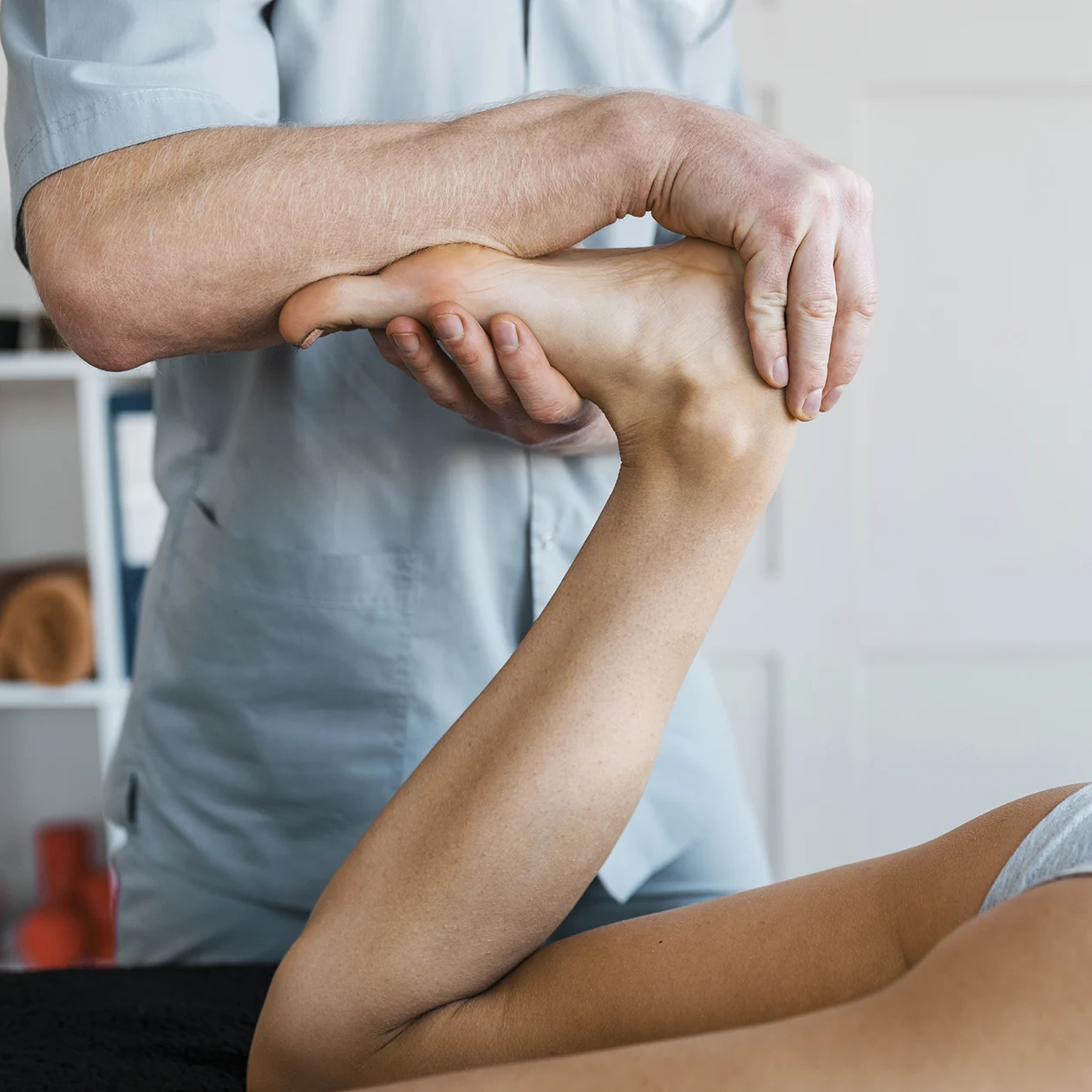 fisioterapéuta profesional en clínica aplica fisioterapia y rehabilitación de pierna, pie y tobillo a mujer